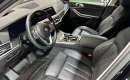 Interior of a modern BMW car, featuring black leather seats enhanced with interior ceramic coating for cars, a digital dashboard, steering wheel with BMW logo, and a sleek center console with various controls and gear selector.